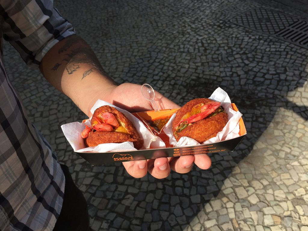 Embalagem do Foodtruck Acarajé Carioca, com duas acarajés para degustação nos eventos